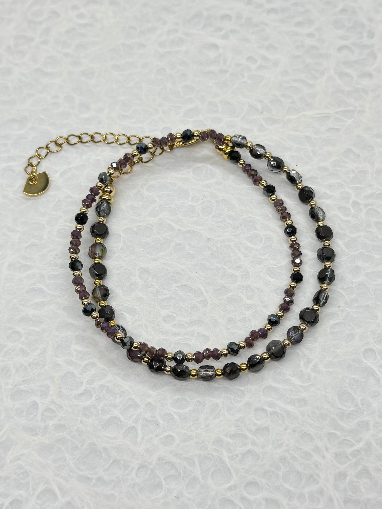 Two beaded necklaces on a textured white surface