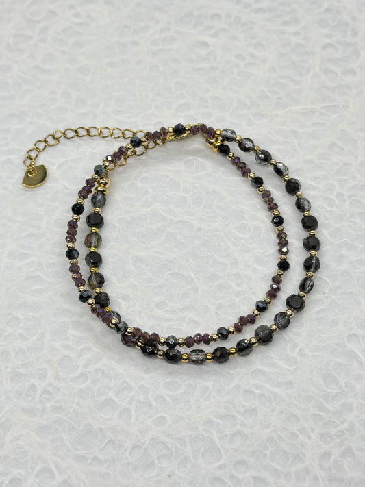 Two beaded necklaces on a textured white surface