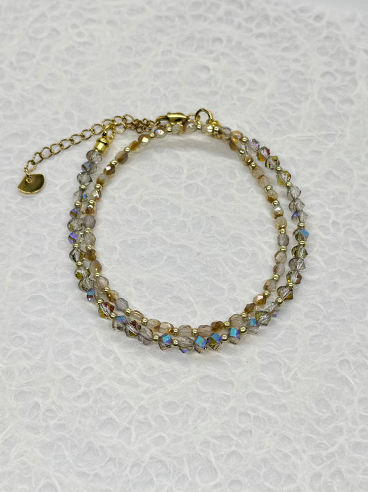 Multistrand beaded bracelet with gold accents on a textured white background