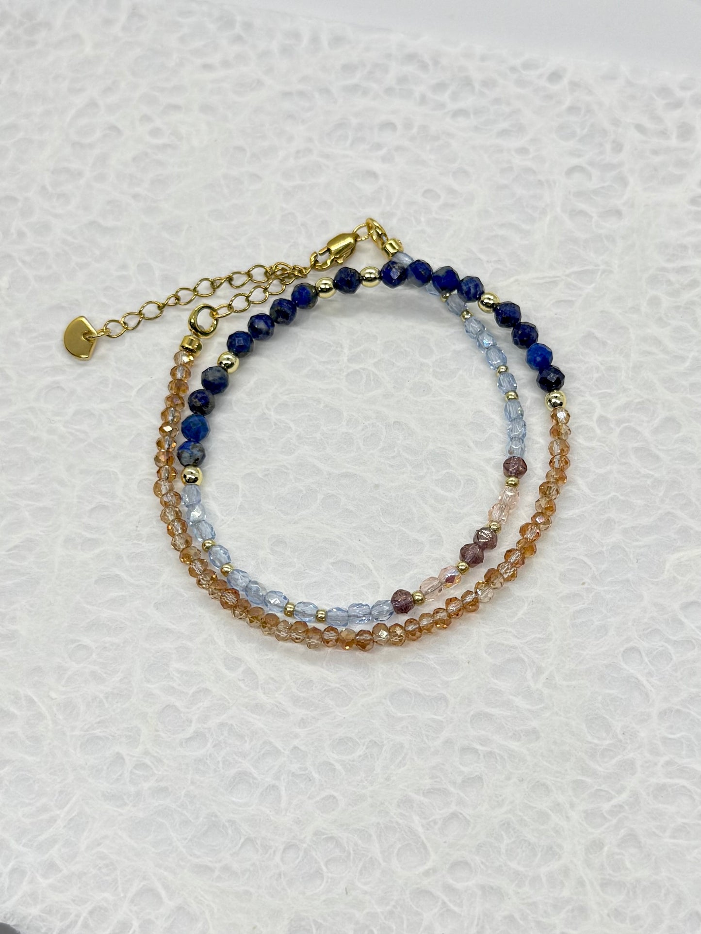 Stack of beaded bracelets on a textured white surface