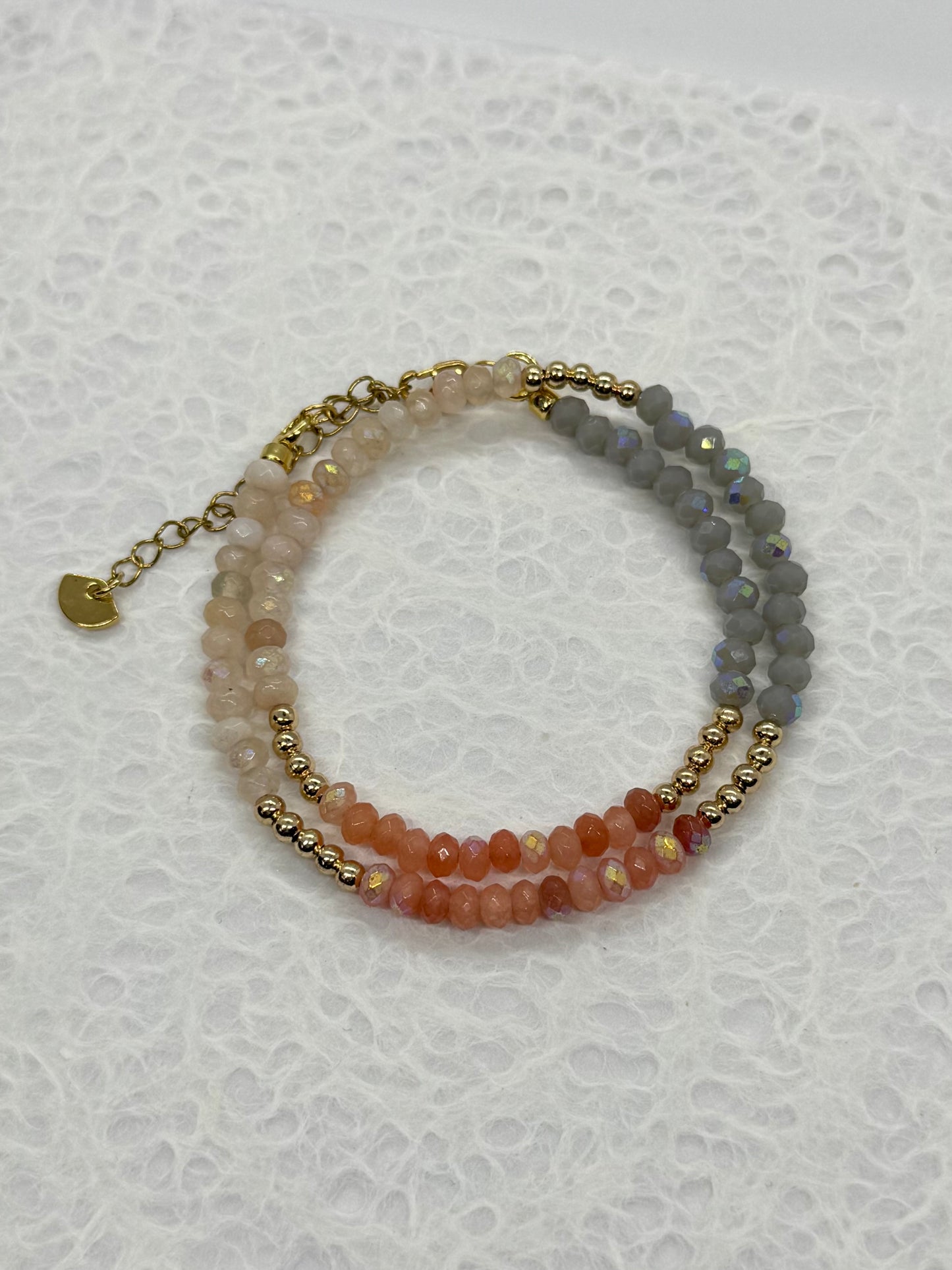 Two beaded bracelets on a textured white surface