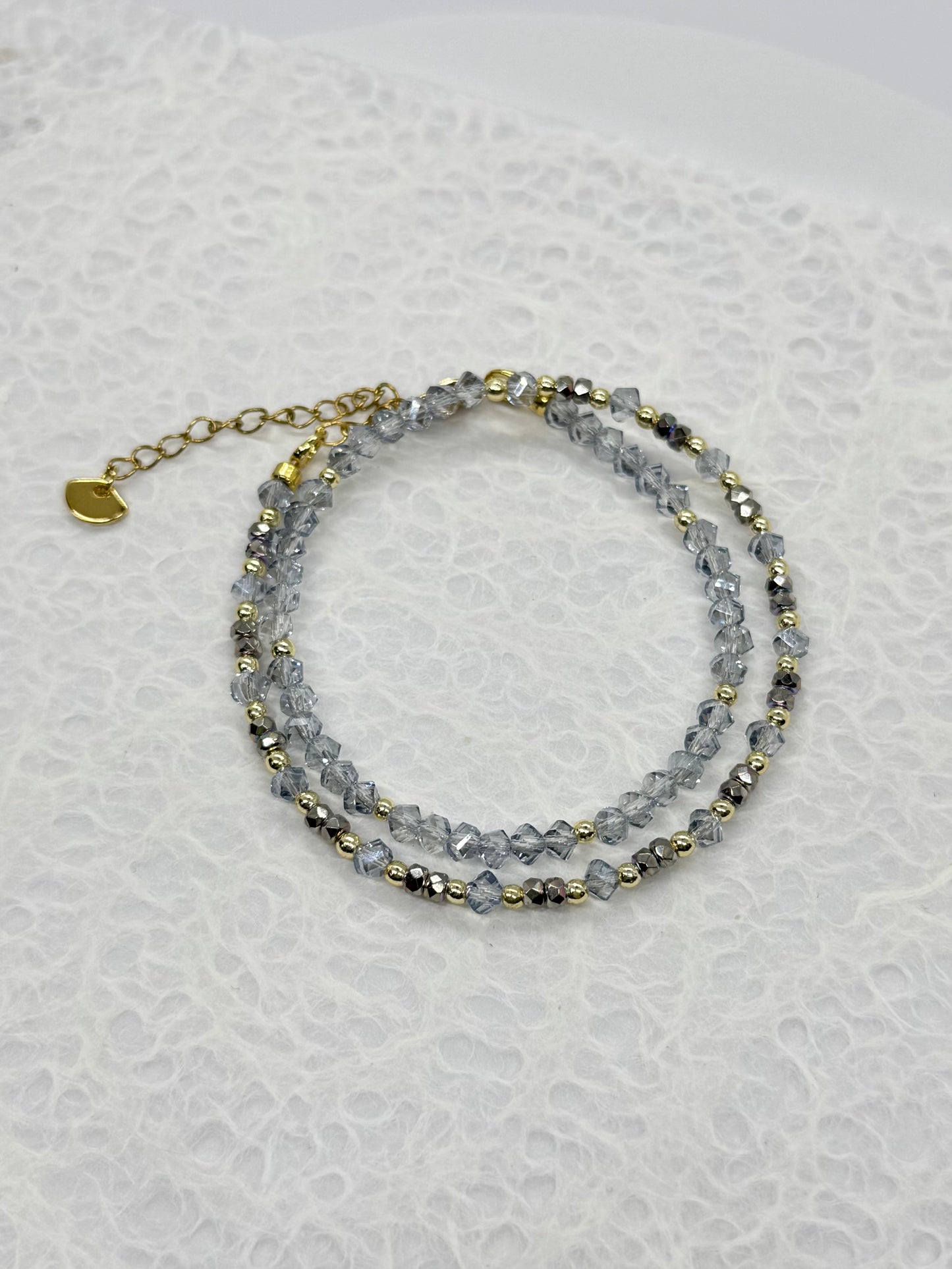 Stack of beaded bracelets on a textured white surface