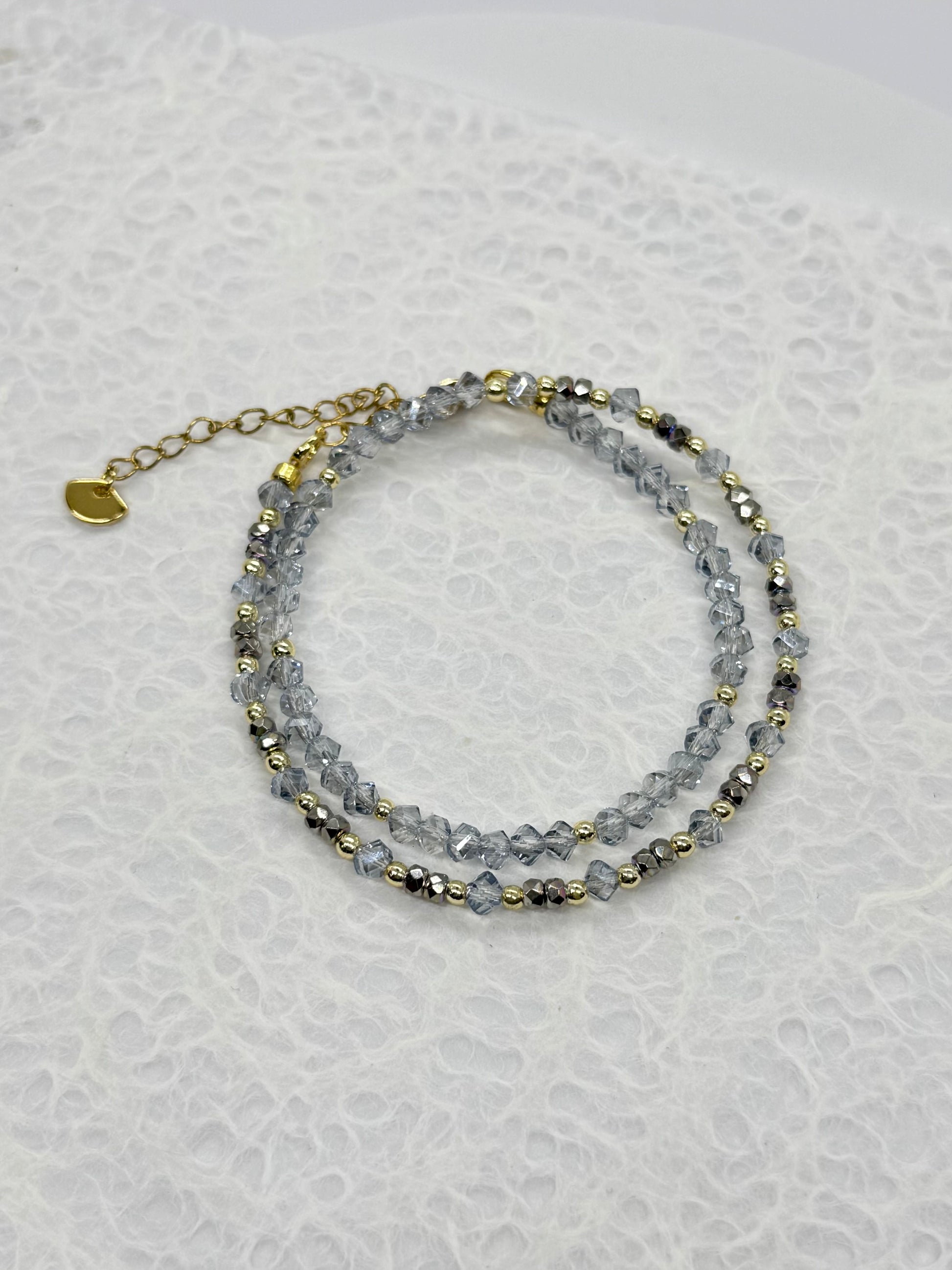 Stack of beaded bracelets on a textured white surface