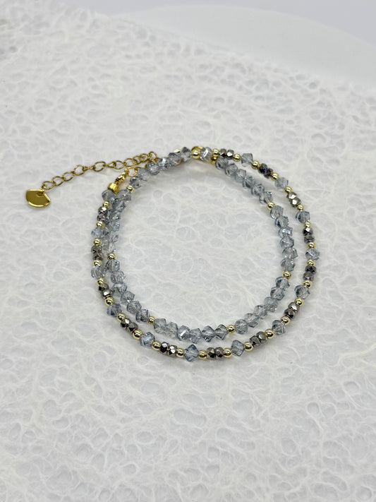 Stack of beaded bracelets on a textured white surface