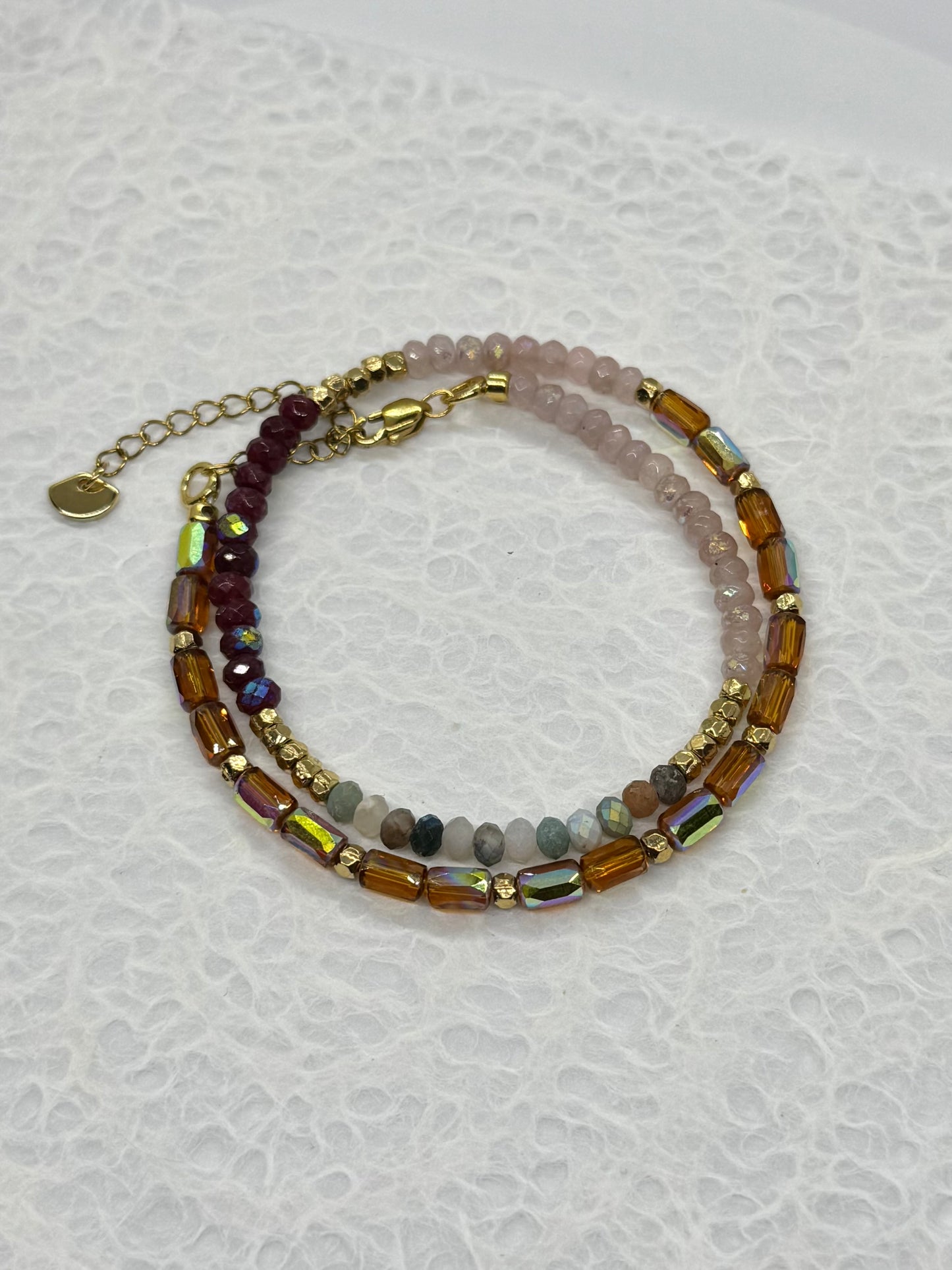 Stack of beaded bracelets on a textured white surface