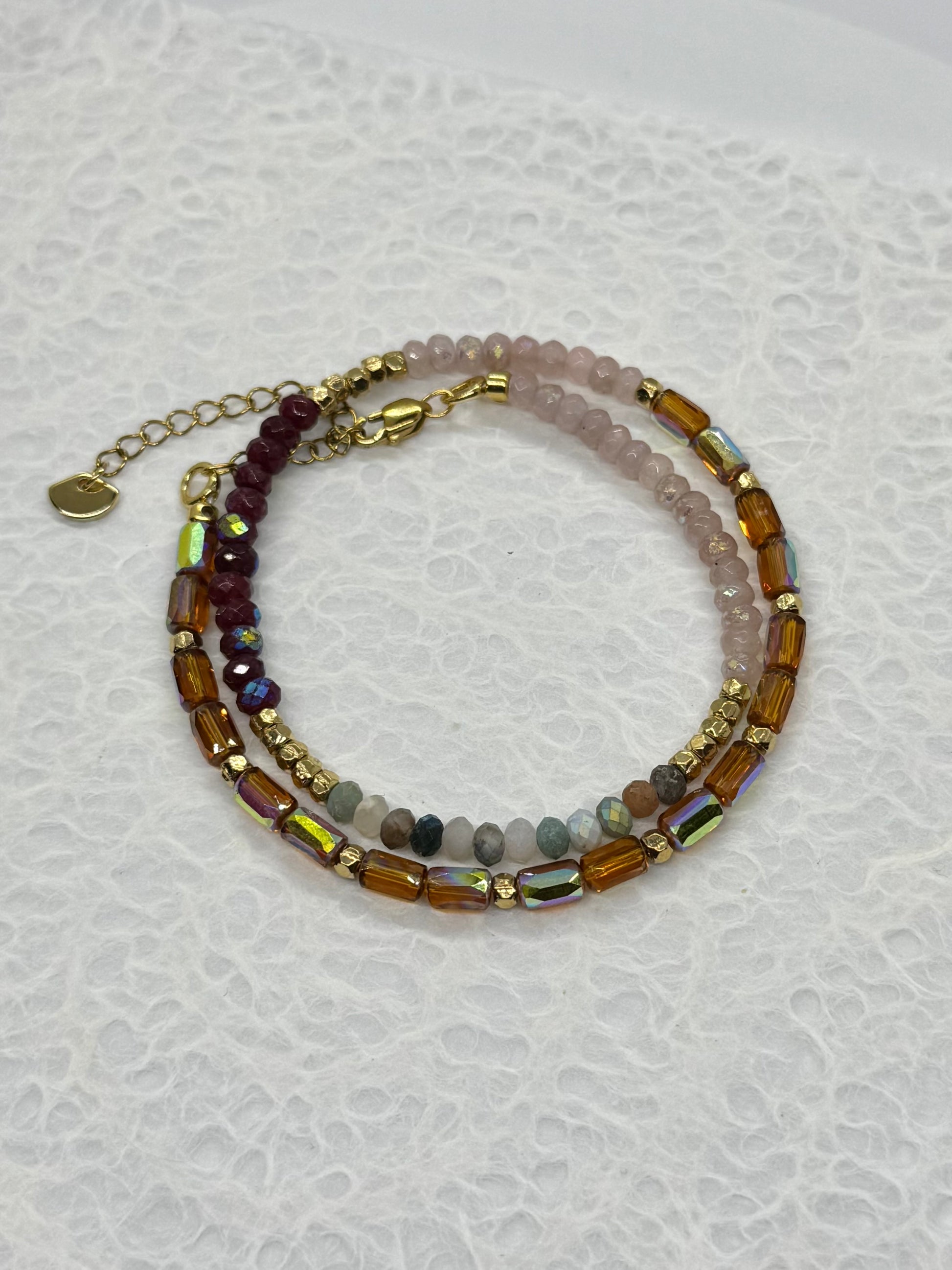 Stack of beaded bracelets on a textured white surface