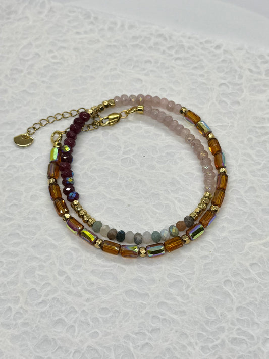 Stack of beaded bracelets on a textured white surface