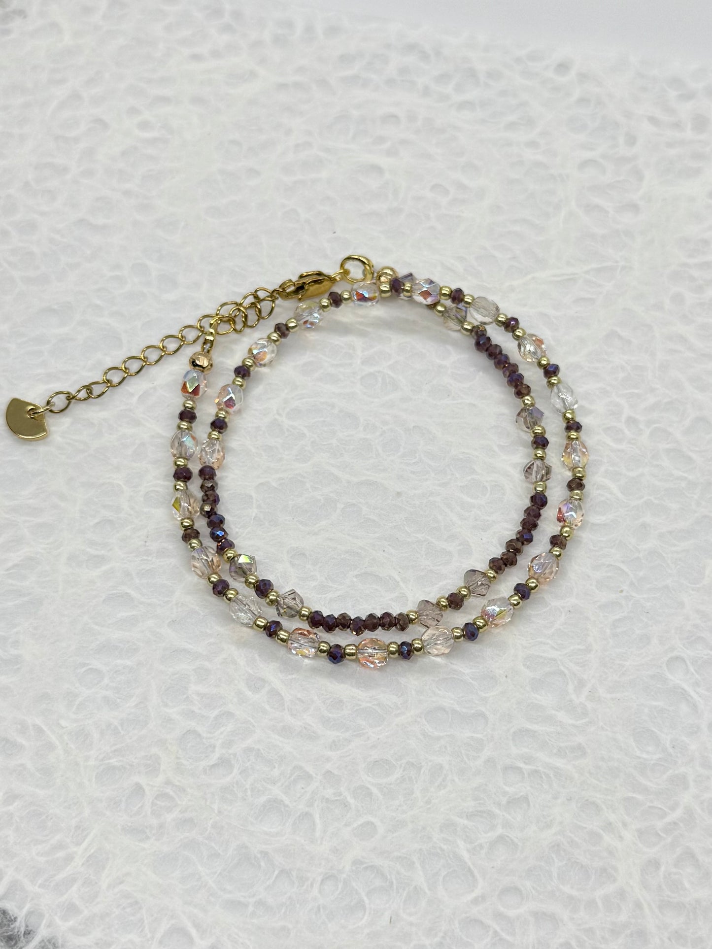 Stack of beaded bracelets on a textured white surface