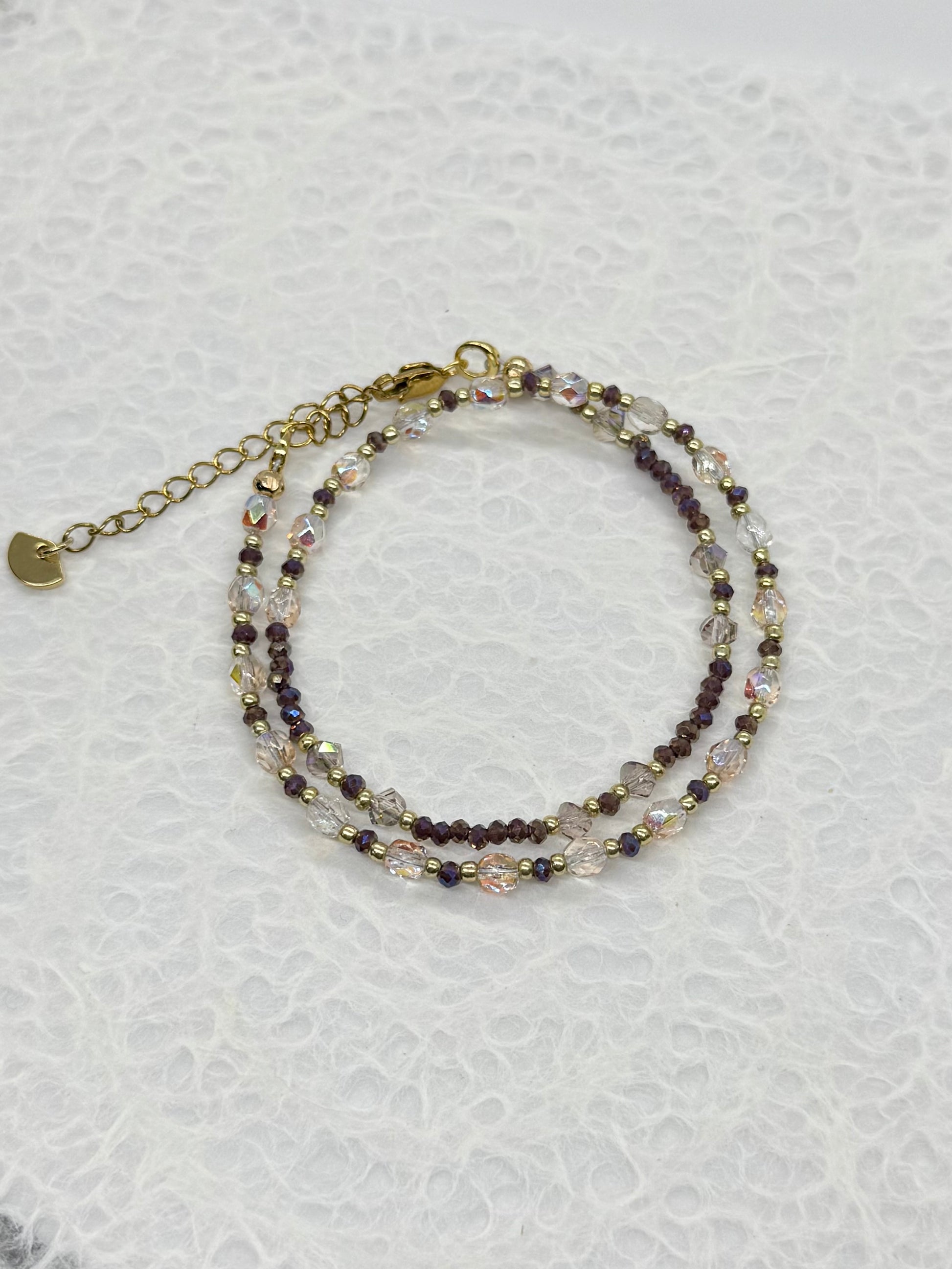Stack of beaded bracelets on a textured white surface
