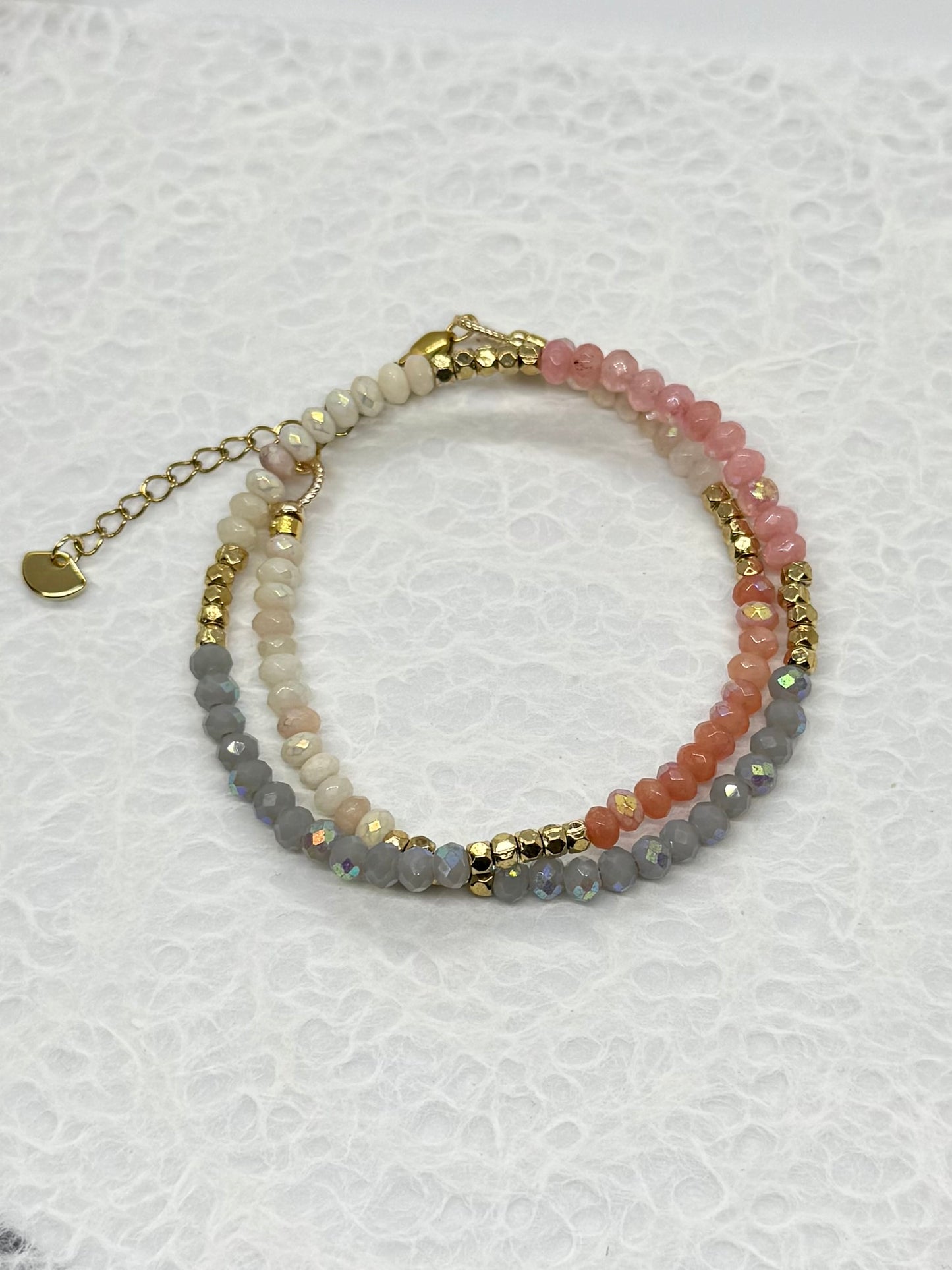 Multicolored beaded bracelet with gold accents on a white background