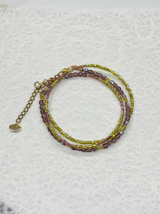 Stack of beaded bracelets on a textured white surface