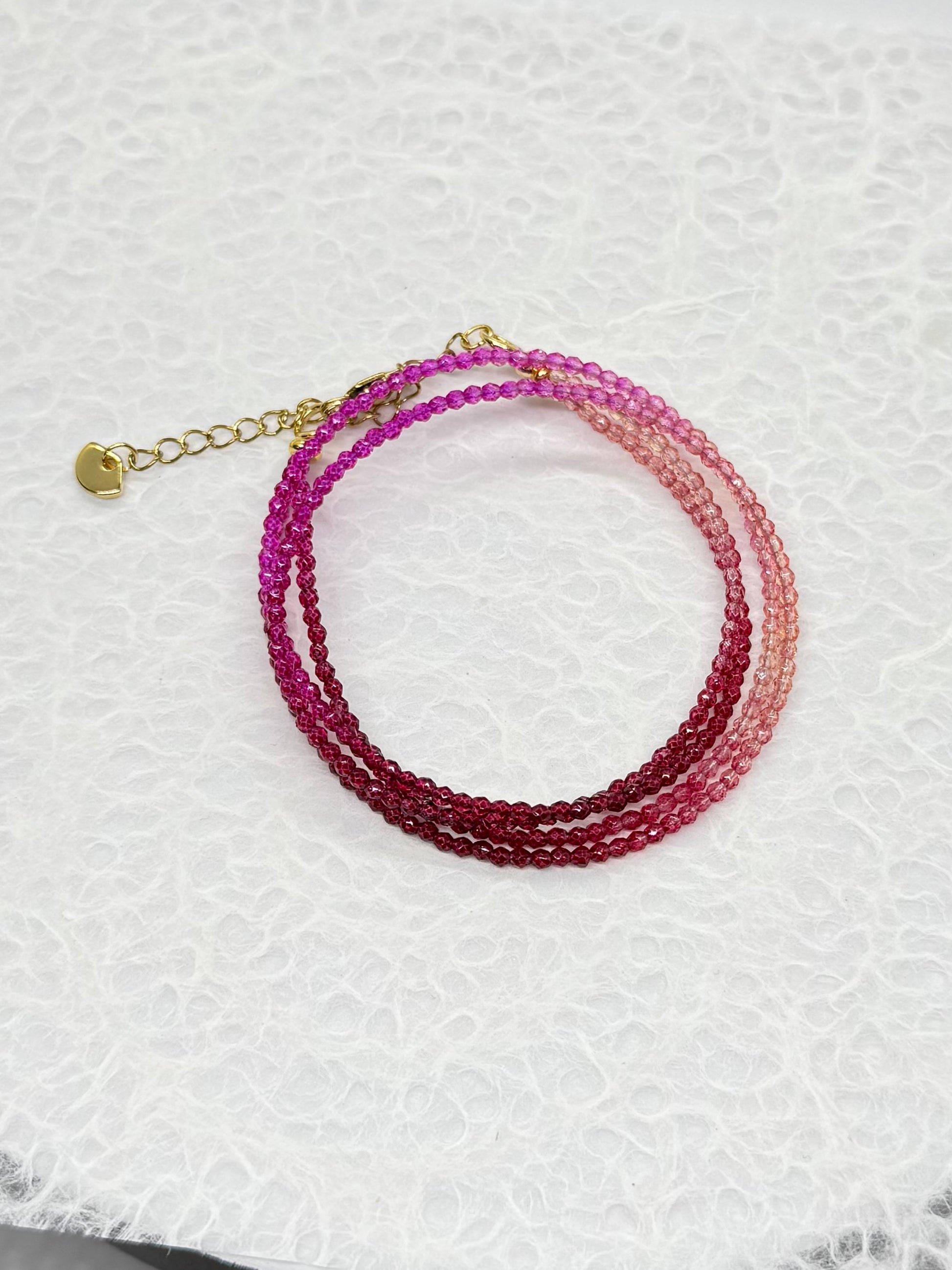 Multistrand beaded bracelet with gradient colors on a textured white background