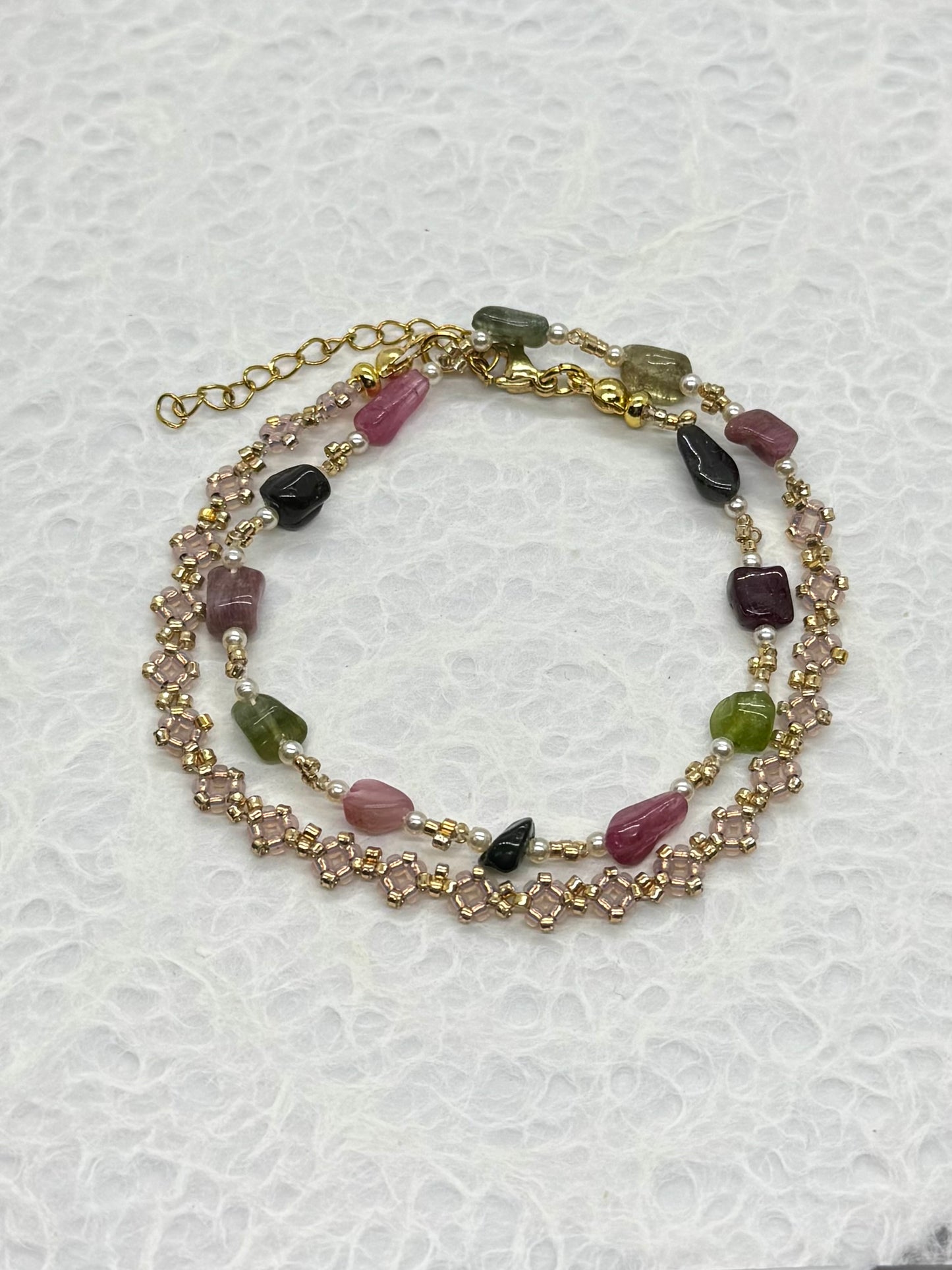 Multicolored beaded bracelet on a textured white background