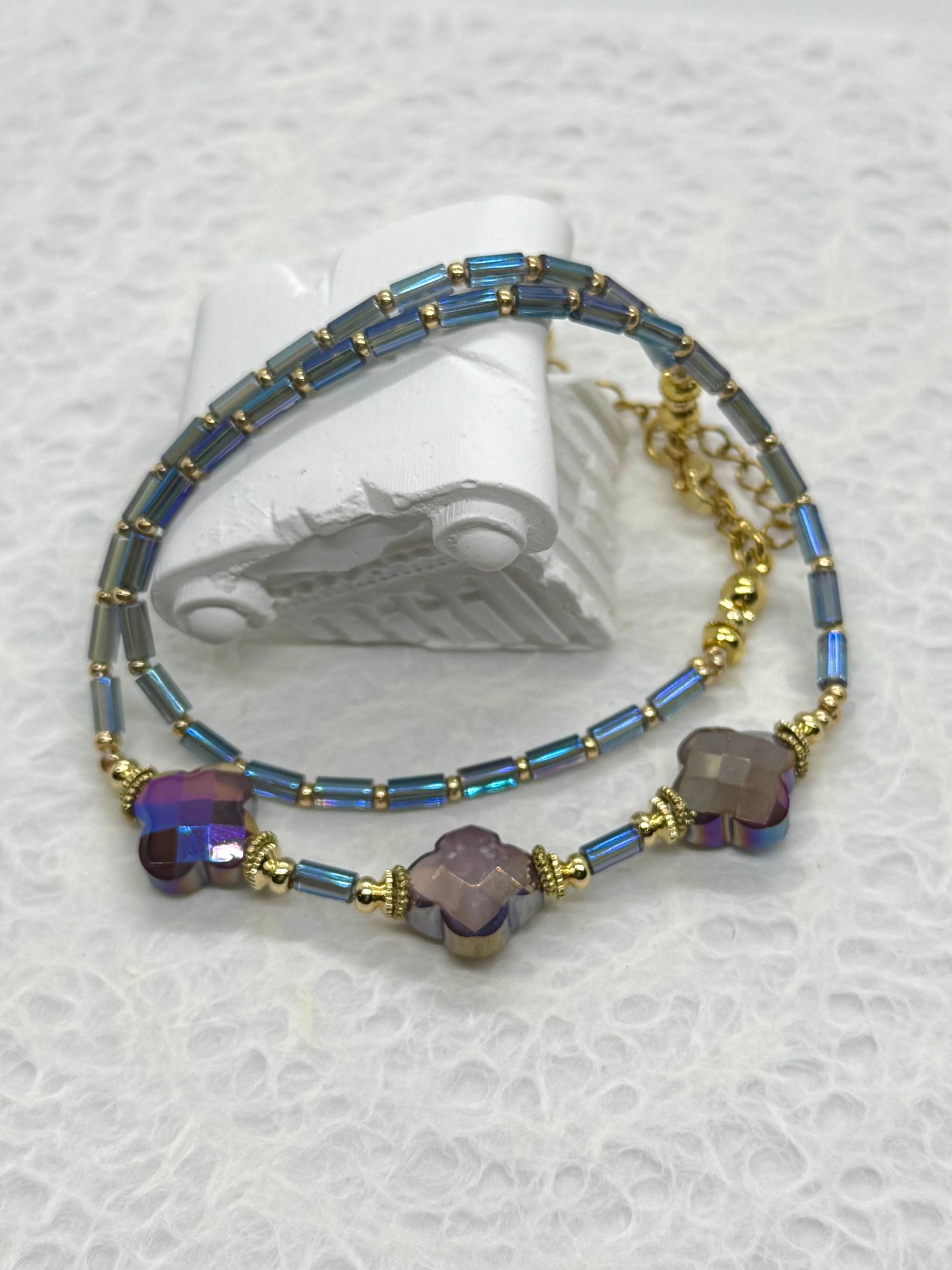 Beaded bracelet with blue and purple beads on a white background