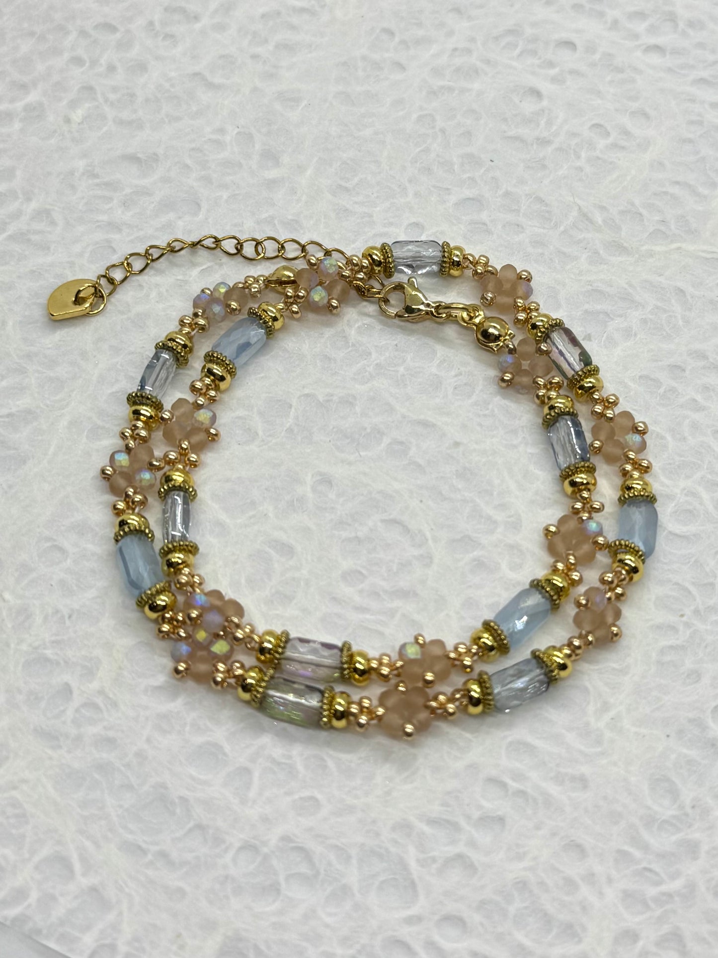 Beaded bracelet with gold accents on a textured white background