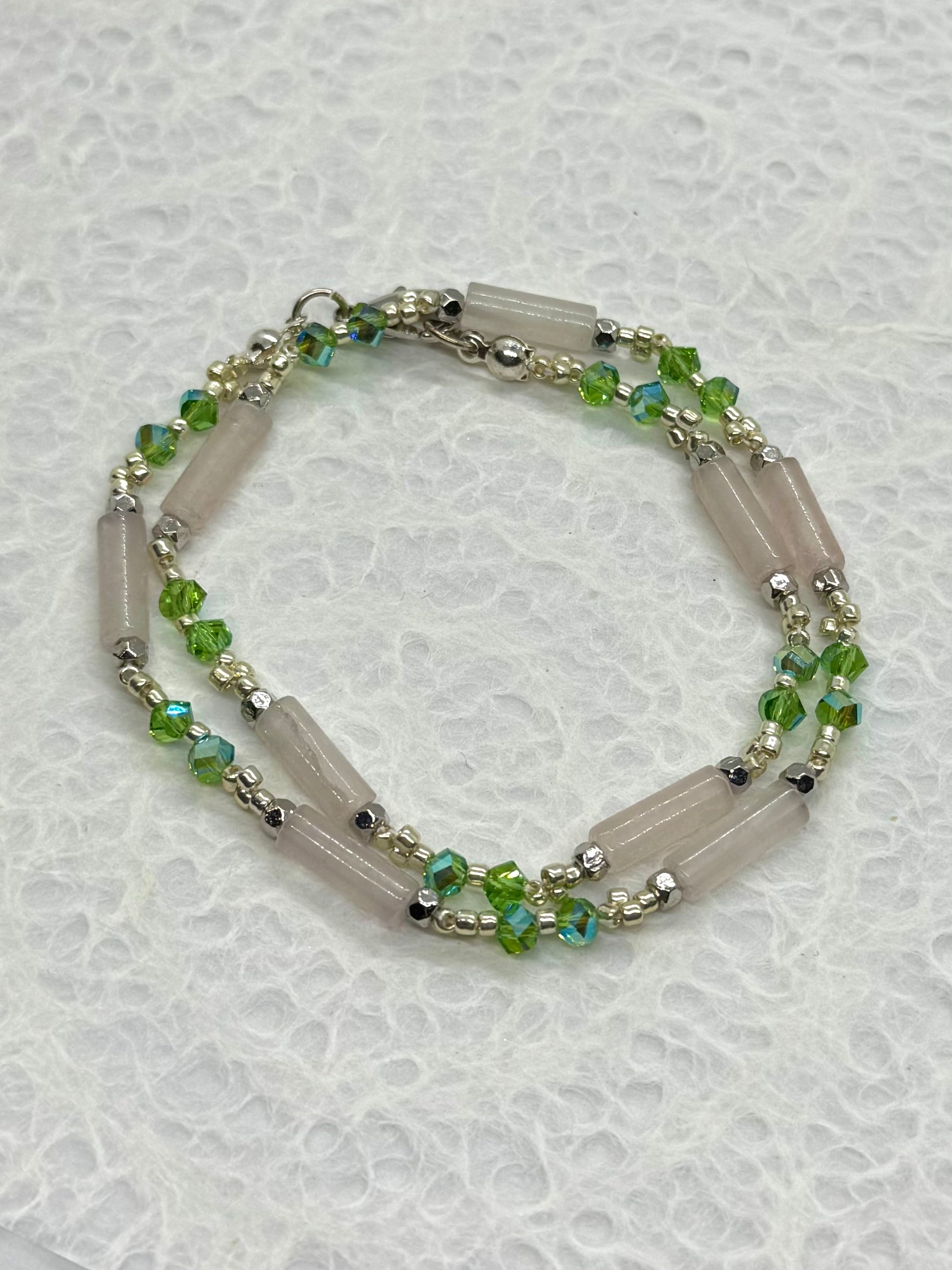 Necklace with green beads on a textured white background