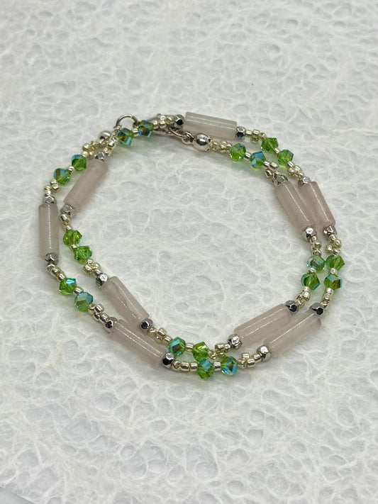 Necklace with green beads on a textured white background