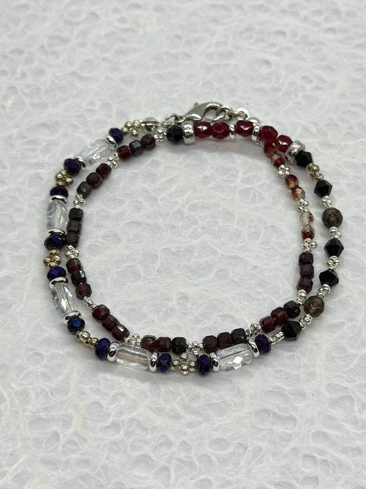 Beaded bracelet with red, blue, and clear beads on a white background