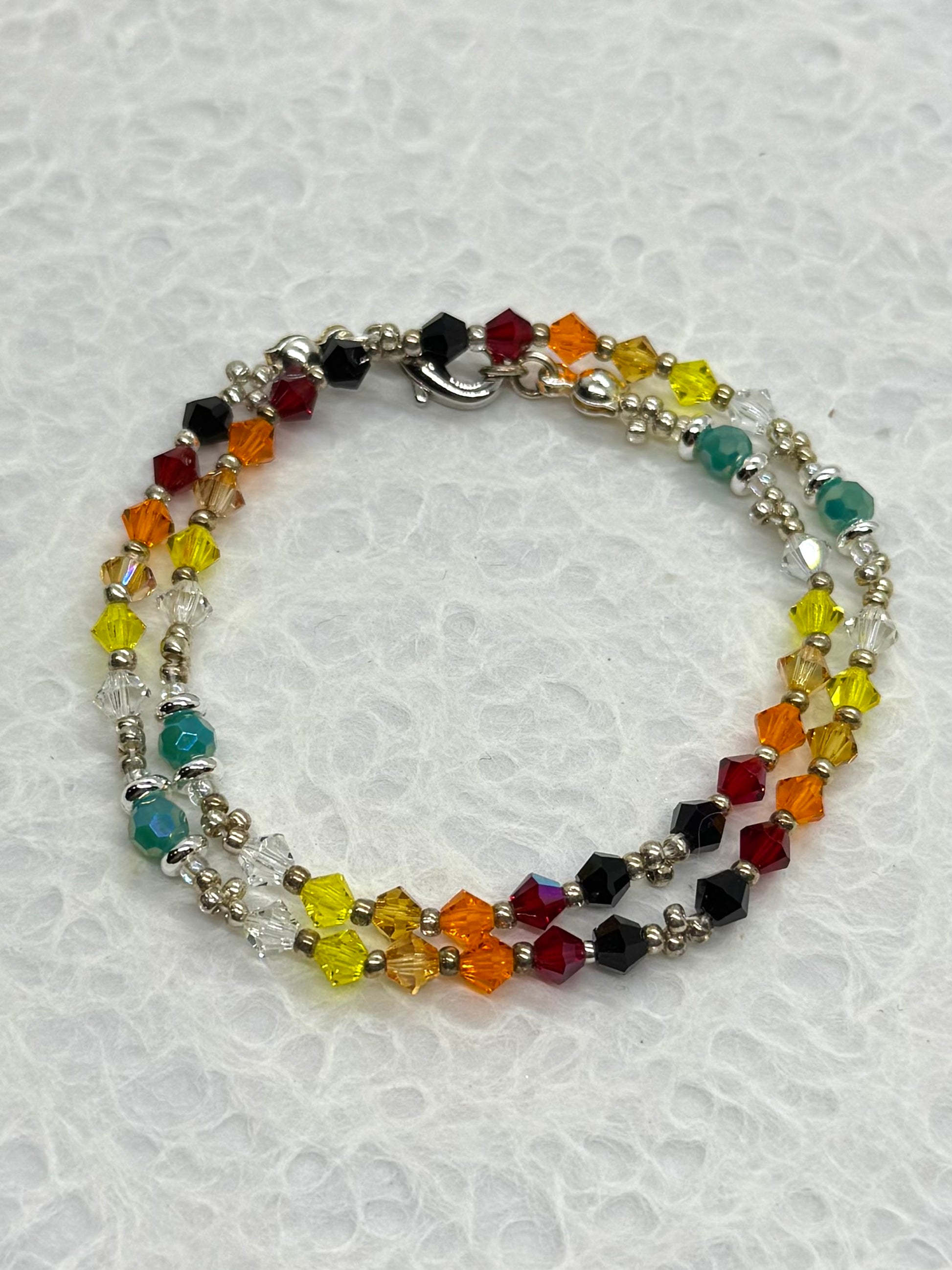 Multicolored beaded bracelet on a textured white background