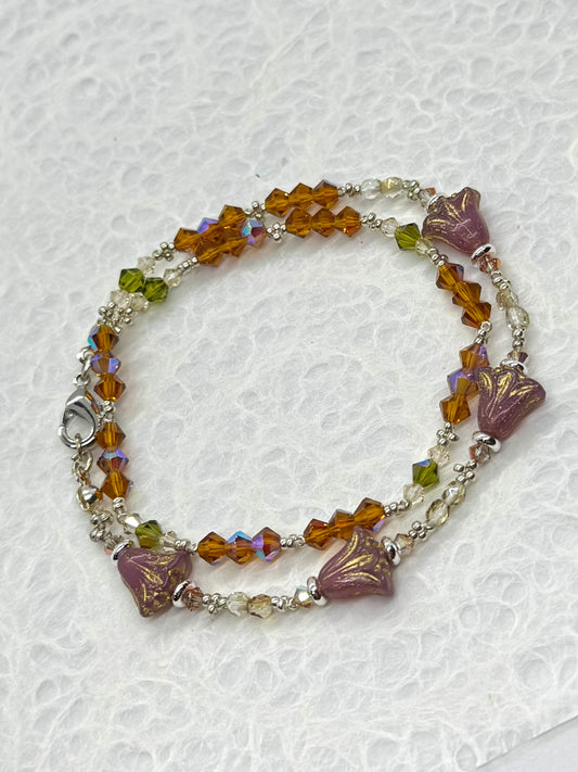 Beaded bracelet with floral designs on a textured white background