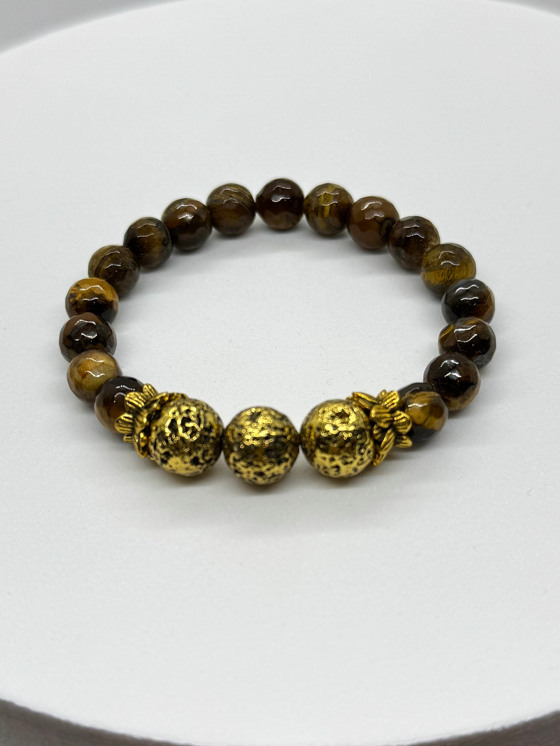 Bracelet with brown beads and gold accents on a white background
