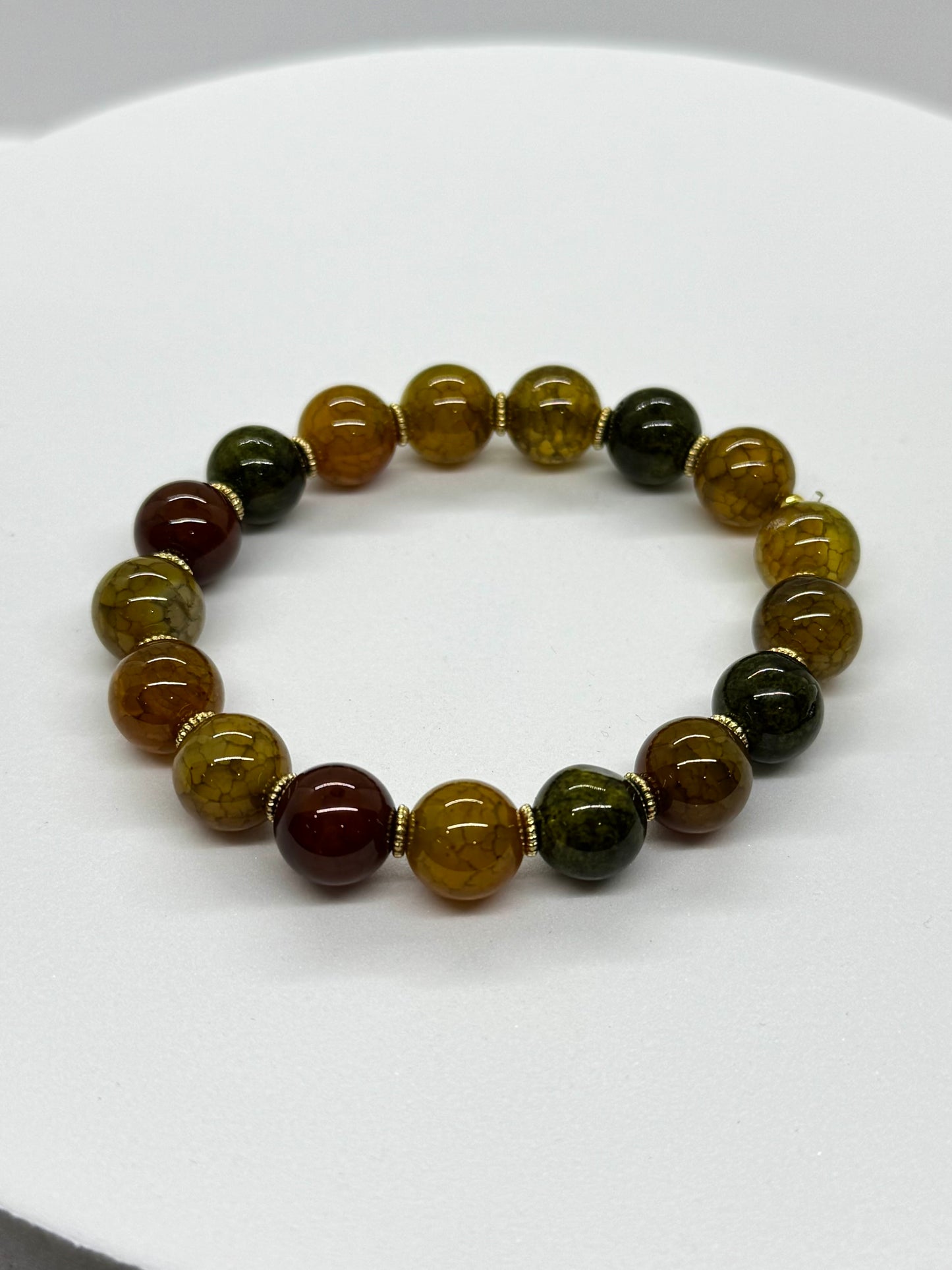 Beaded bracelet with brown and green stones on a white background