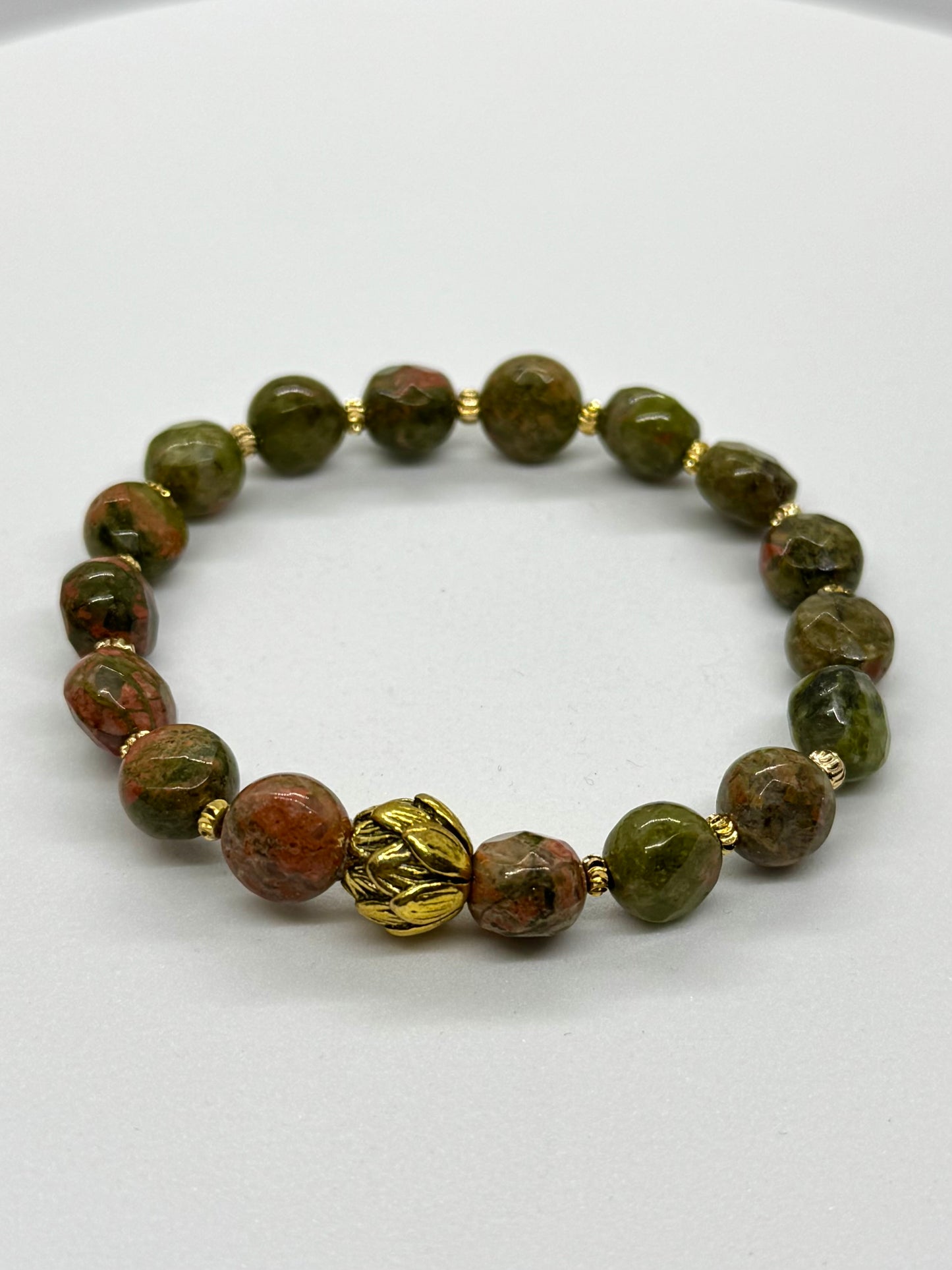Bracelet with green and brown beads on a white background