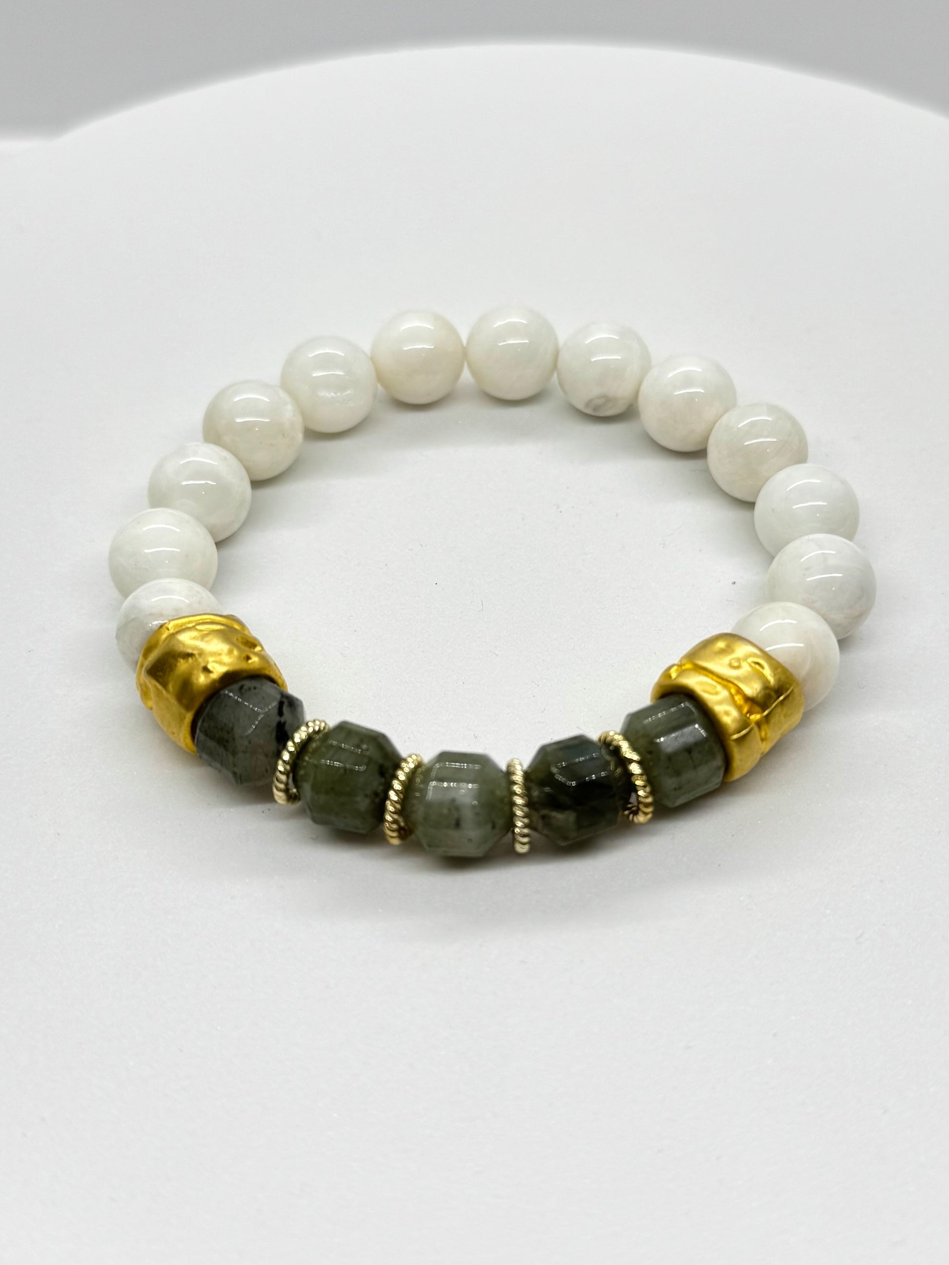Beaded bracelet with white, black, and gold beads on a white background