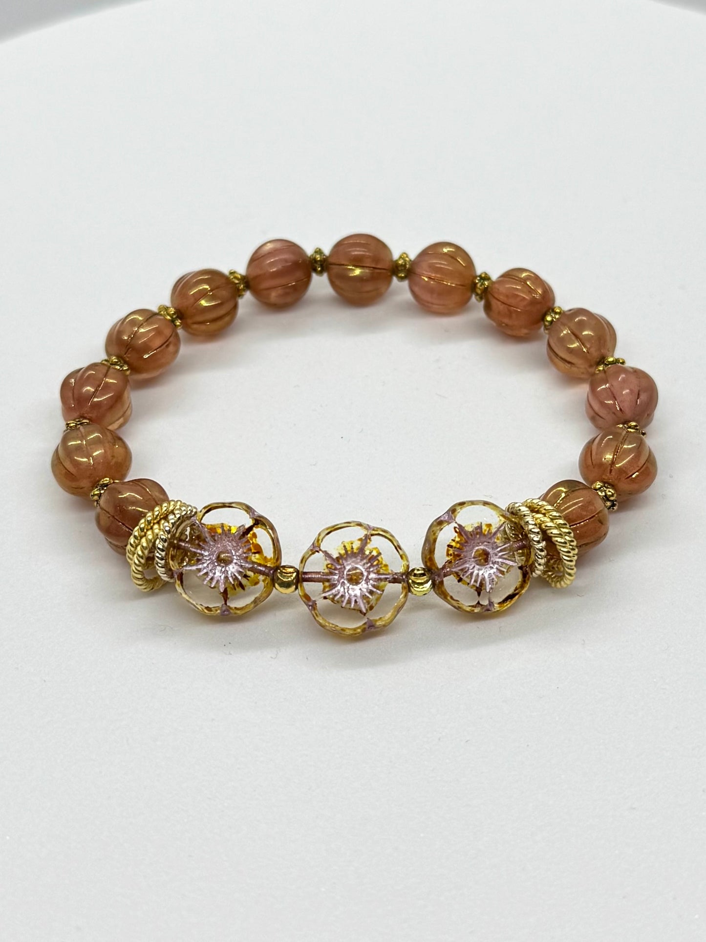 Bracelet with brown beads and gold accents on a white background