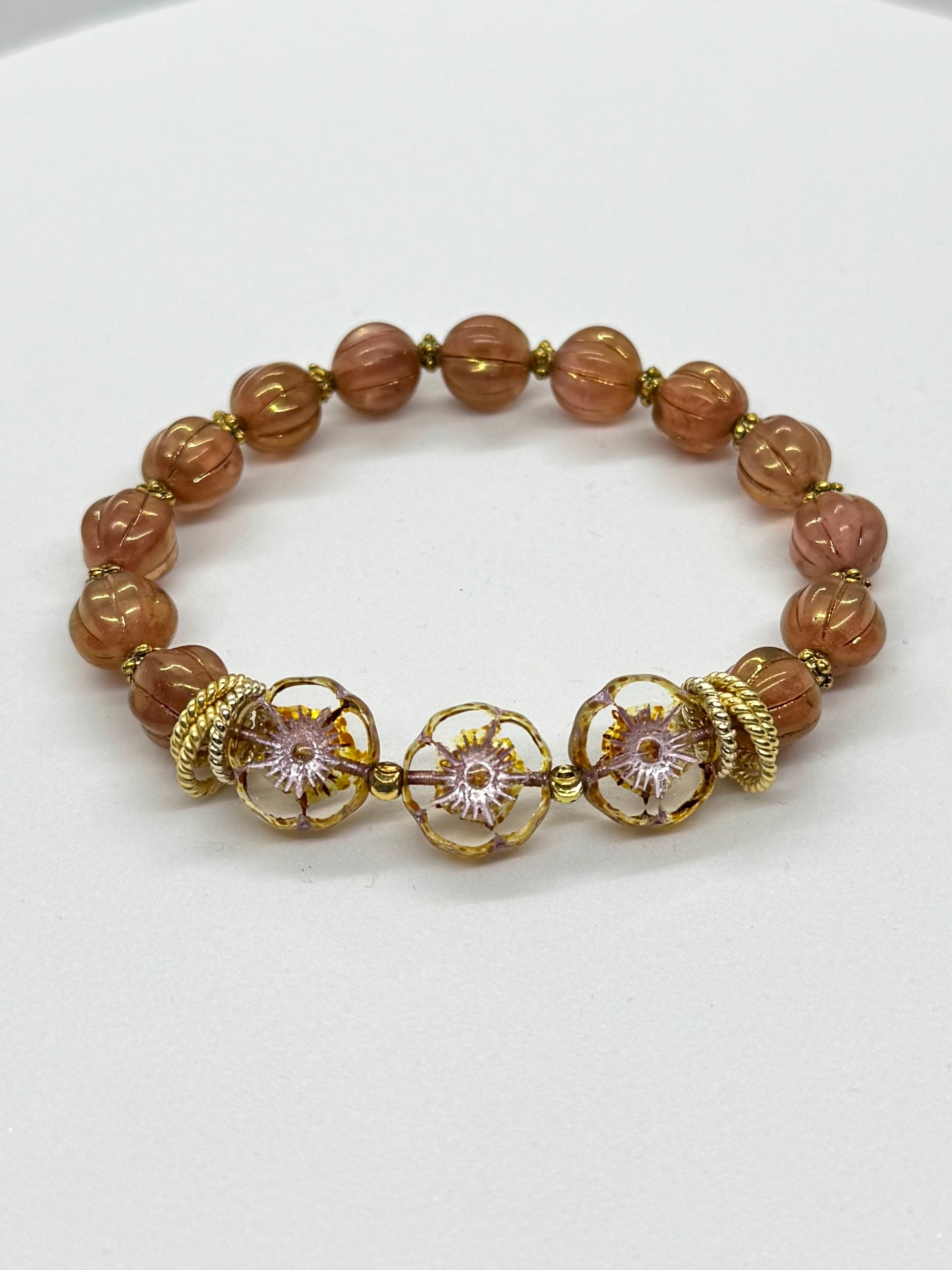 Bracelet with brown beads and gold accents on a white background