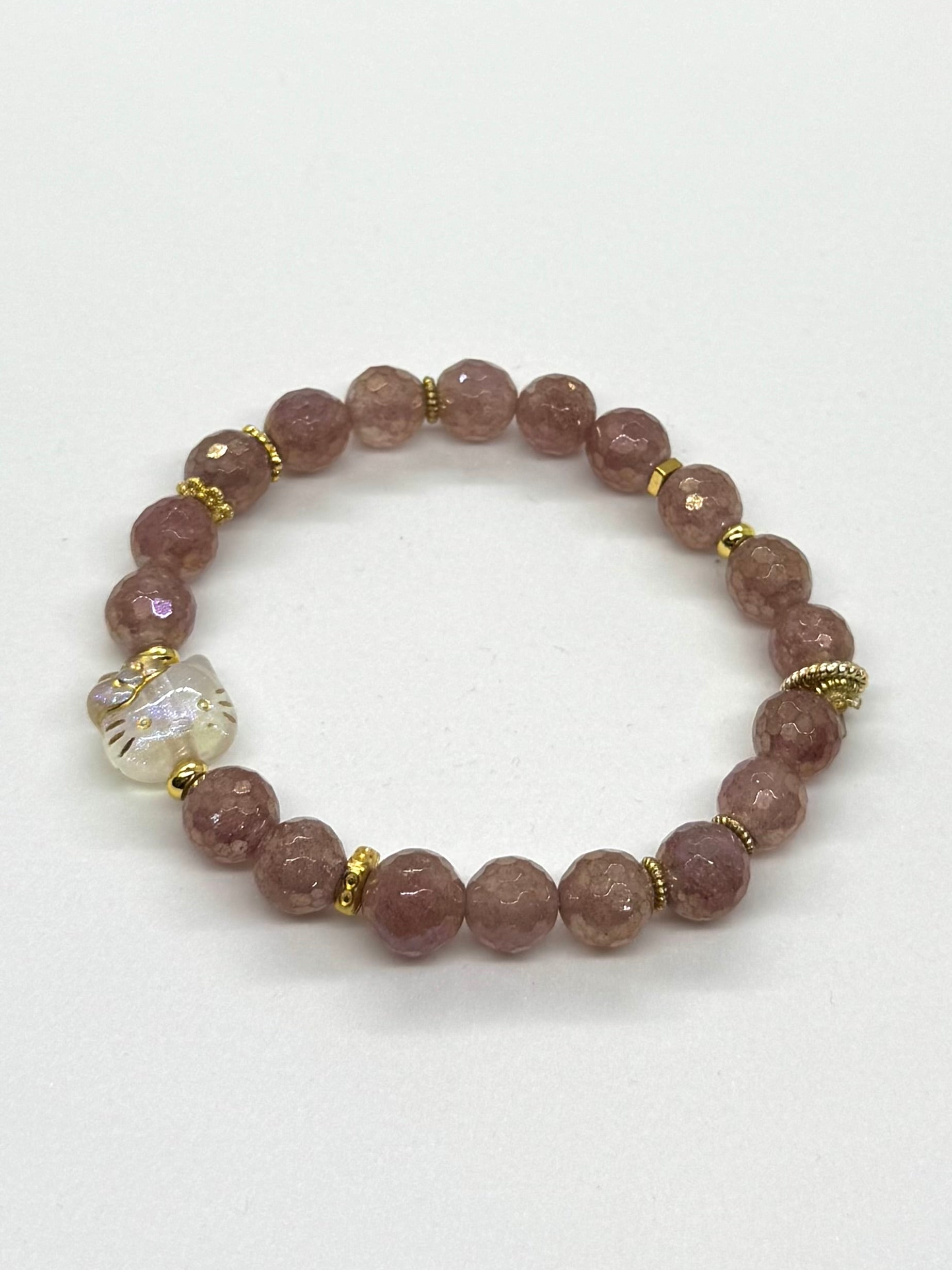 Beaded bracelet with pink beads and gold accents on a white background