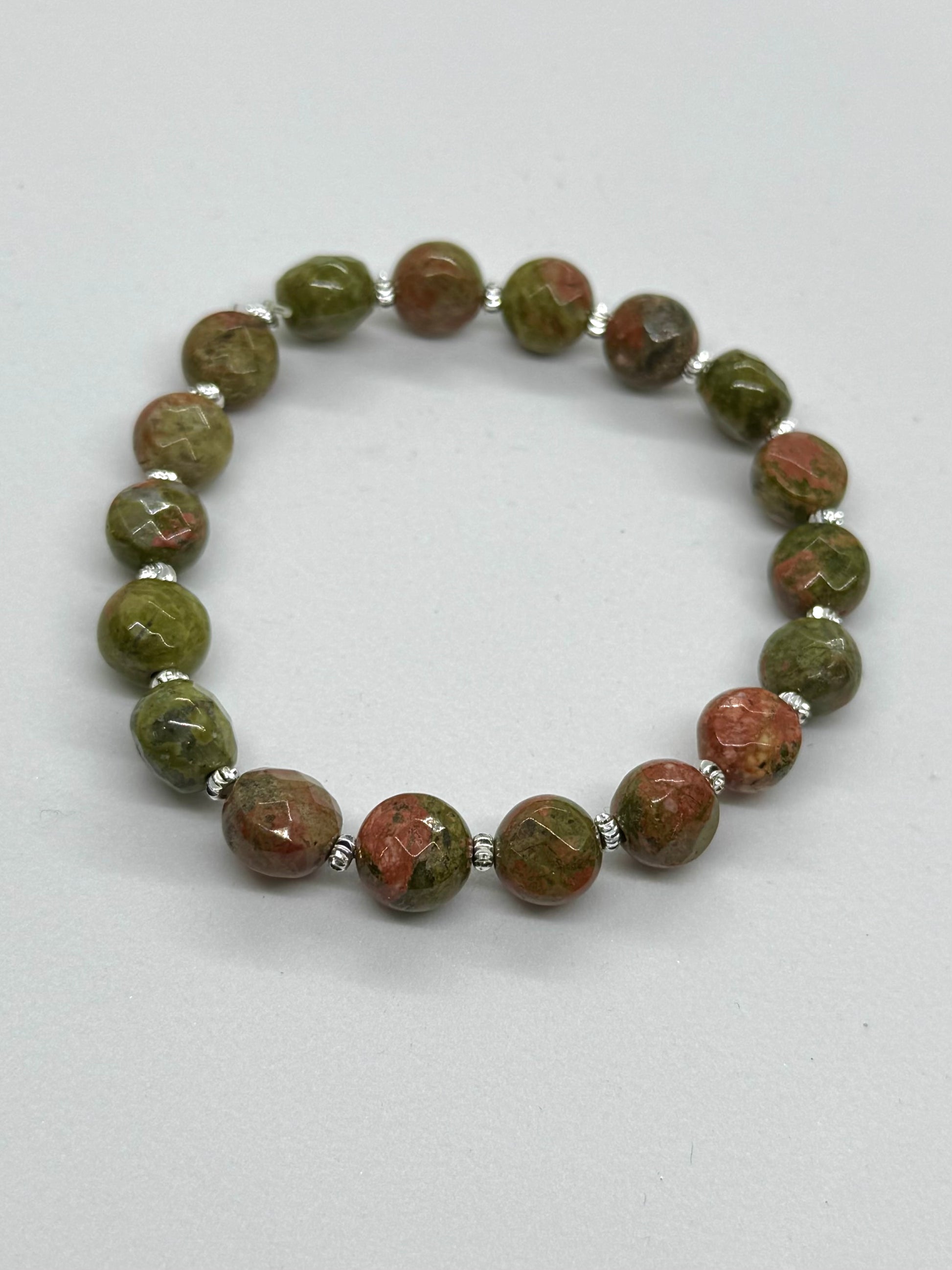 Beaded bracelet with green and brown stones on a white background