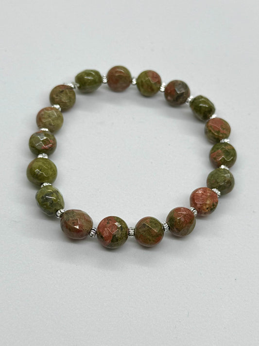 Beaded bracelet with green and brown stones on a white background