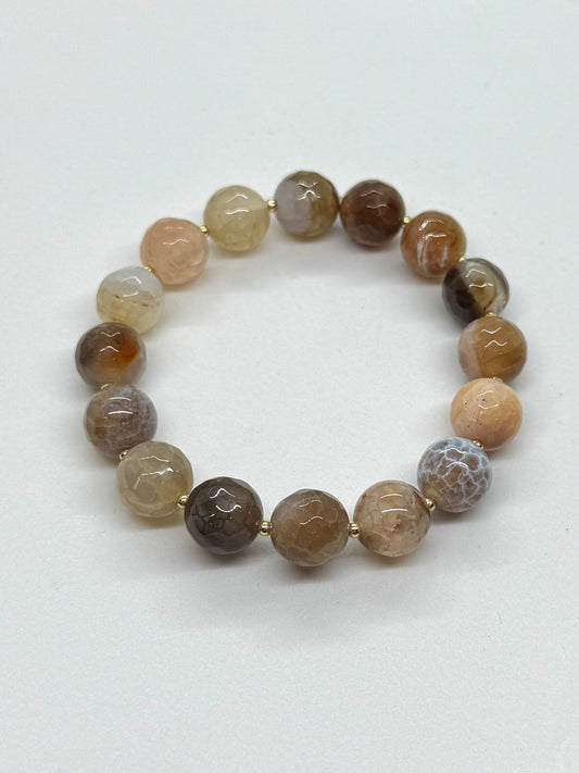 Beaded bracelet with brown and beige stones on a white background