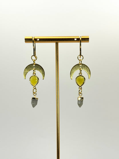 Gold earrings with green gemstones on a white background