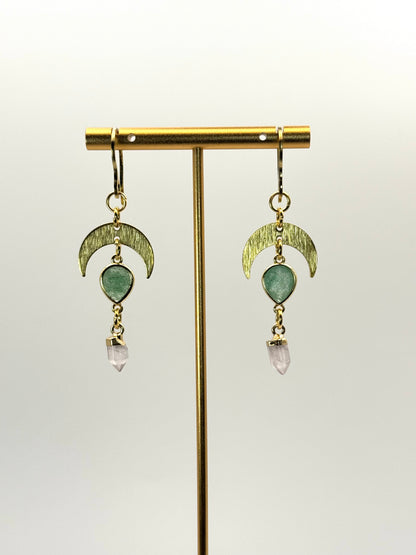 Gold earrings with green and pink gemstones on a white background