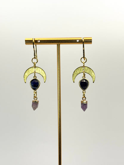 Gold earrings with moon designs and gemstones on a white background
