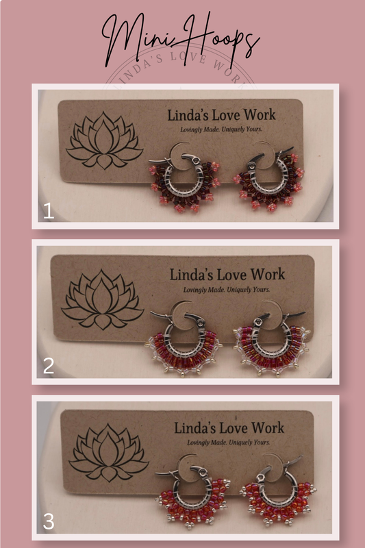 Three pairs of hoop earrings with red beads on a 'Linda's Love Work' branded card against a pink background.