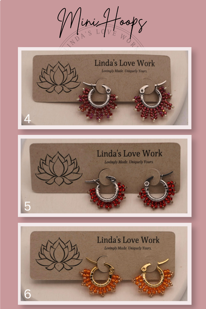 Three pairs of earrings on 'Linda's Love Work' branded cards against a pink background.