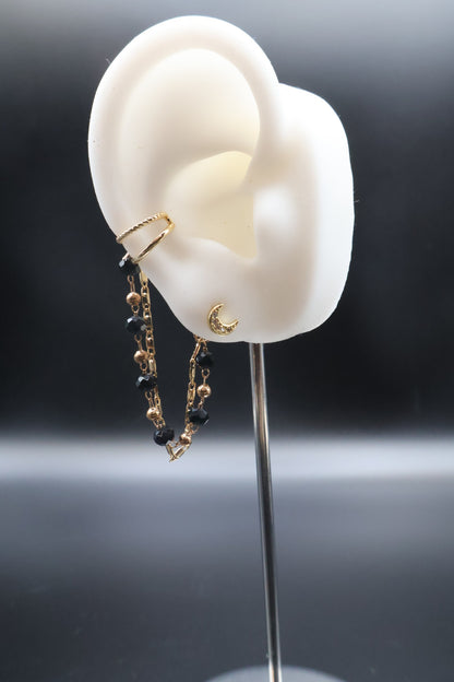 Earring displayed on a white ear model against a dark background