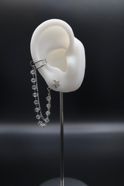 Dangle earring on a mannequin ear with a dark background