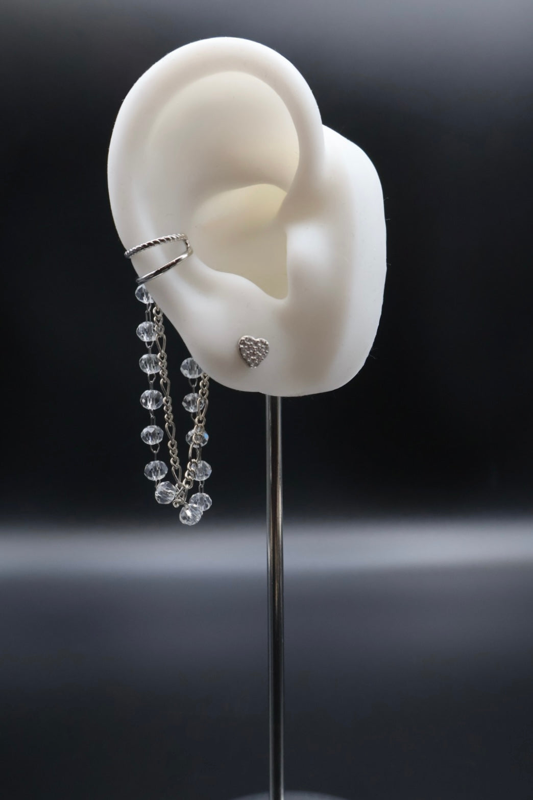 Earring displayed on a stand with a black background