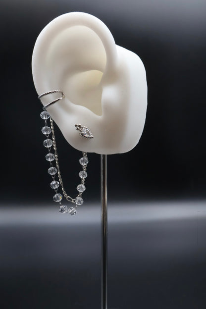 White ear model with earrings on a black background