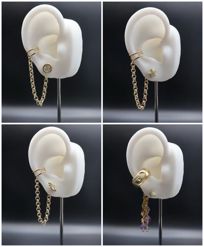 Gold chain earring displayed on a white ear model against a black background