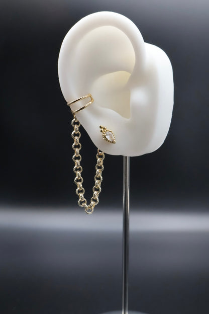 Gold earrings displayed on a white ear model against a dark background