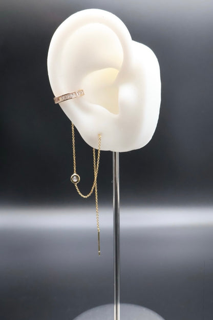 White ear model with jewelry on a dark background