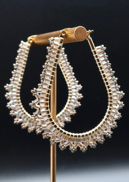 Pair of silver hoop earrings on a black background