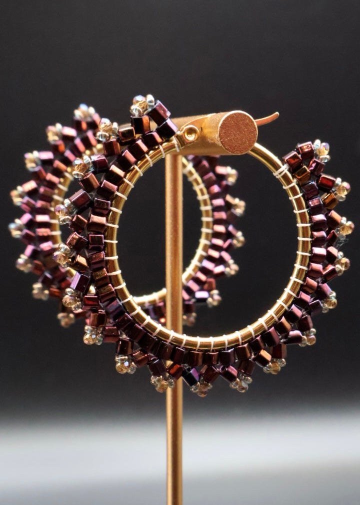 Decorative brooch with circular design and beaded details on a dark background