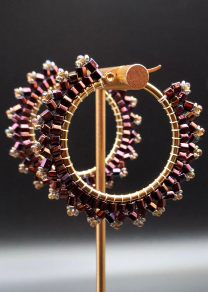 Decorative brooch with circular design and beaded details on a dark background