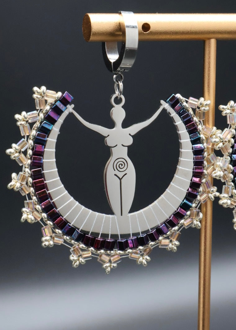 Decorative pendant with a central figure and colorful circular design on a stand.